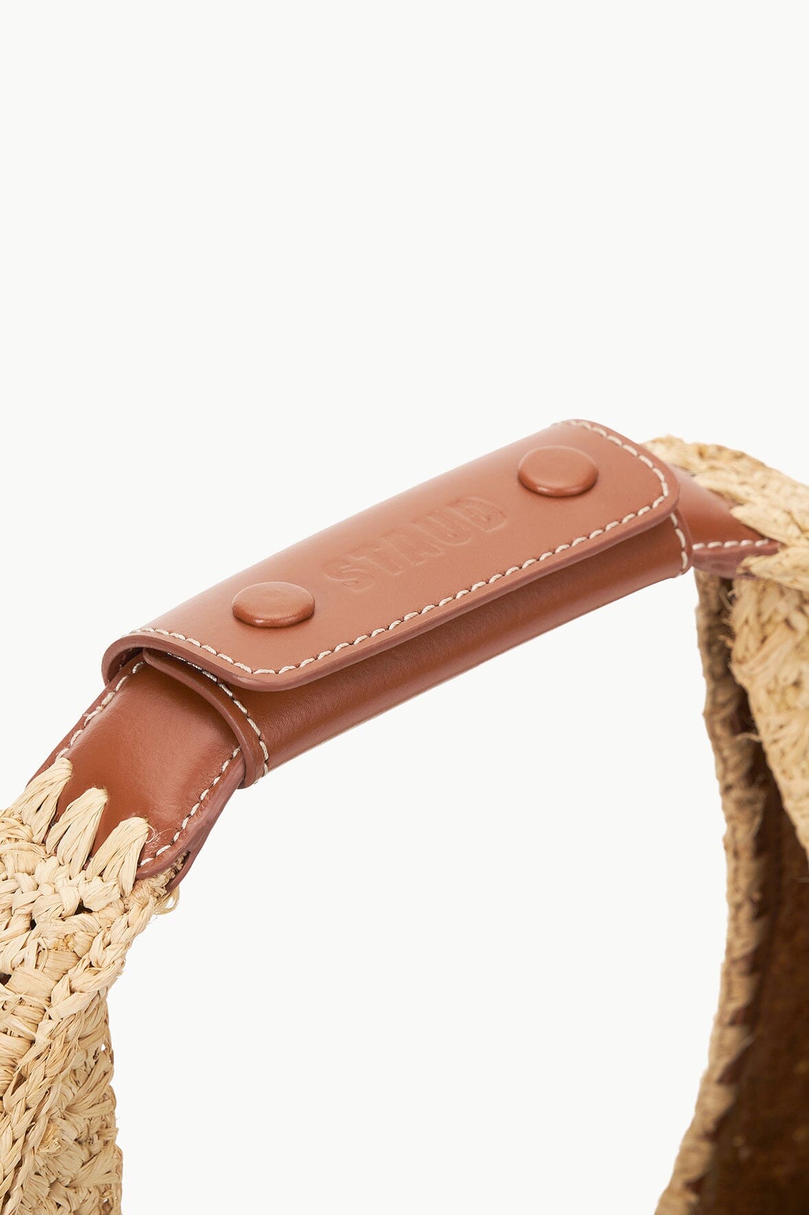 Brown leather-look strap with two stud details on tan raffia moon tote bag