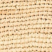 Close-up of natural tan woven straw texture on clutch front.