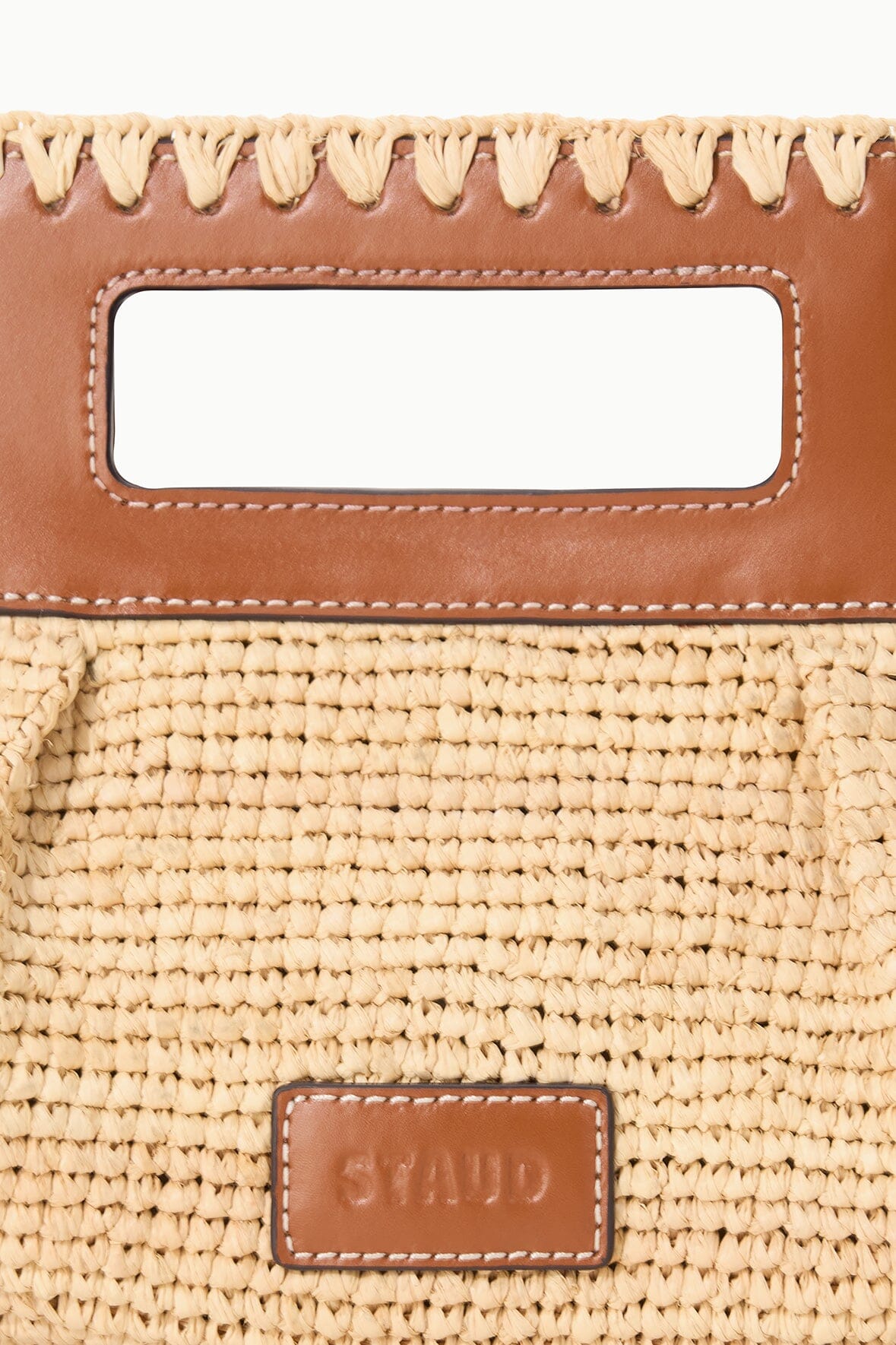 Brown leather trim natural tan straw clutch with rectangular window and logo patch.