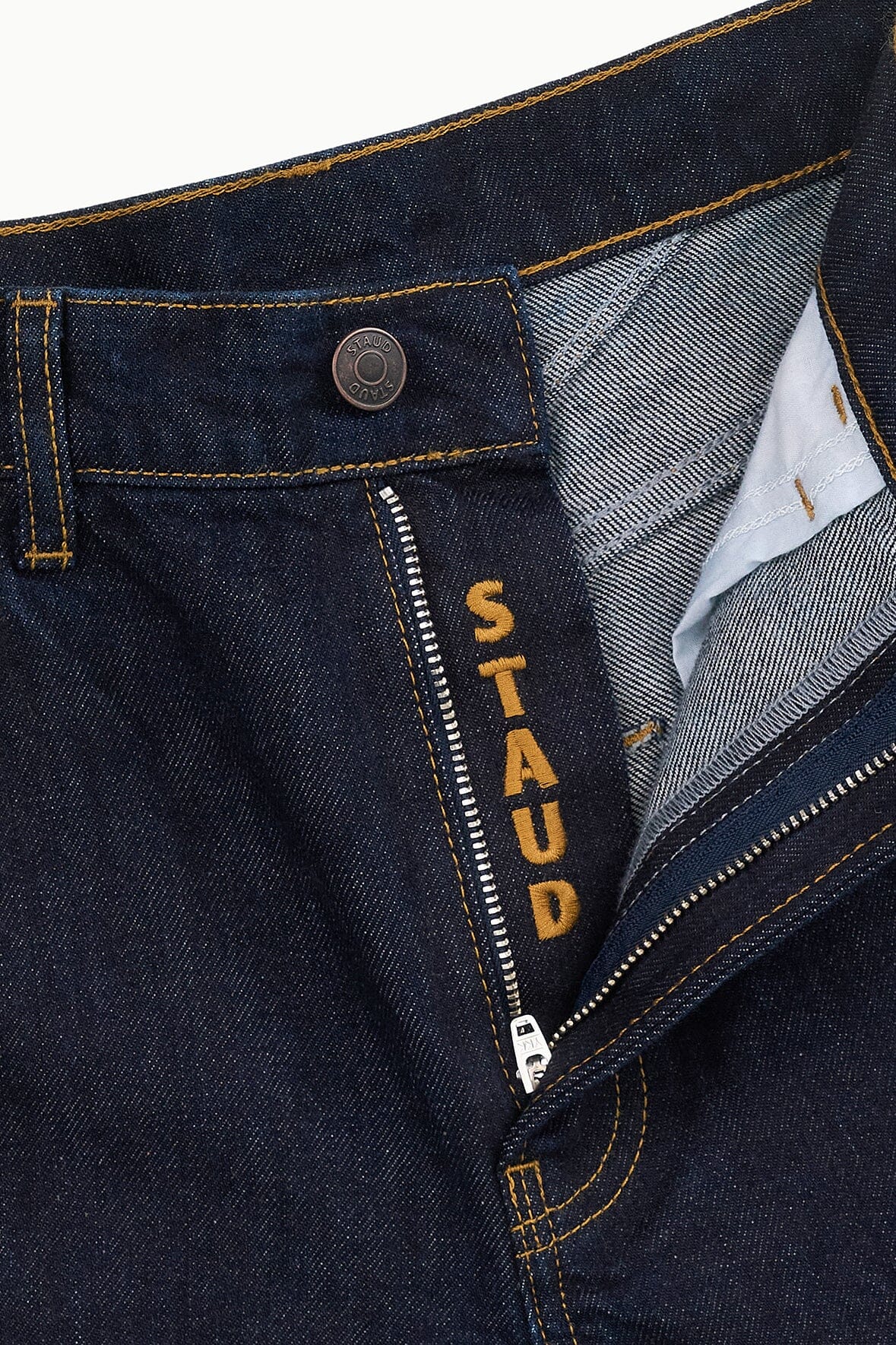 Indigo denim jeans with interior STAUD label and buttoned back pocket area