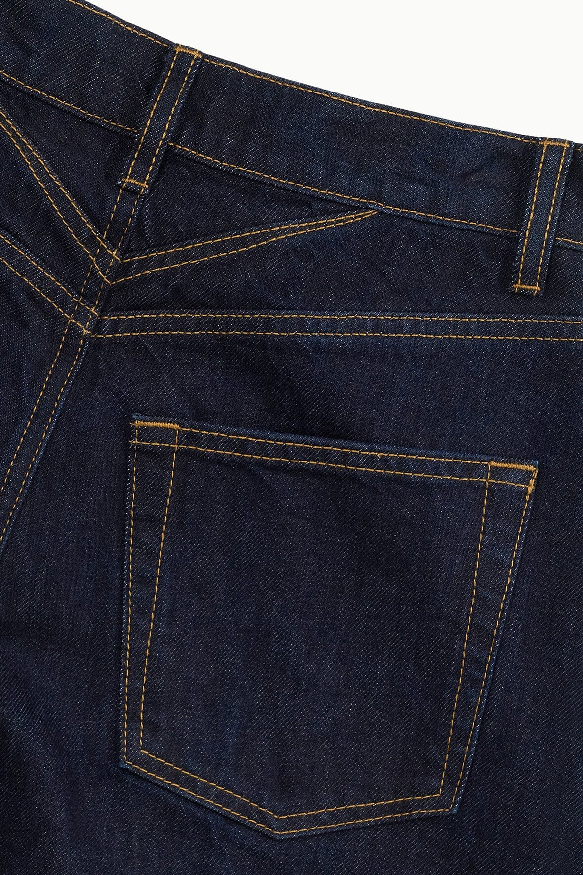 Indigo barrel jean with front pocket and orange-stitched details