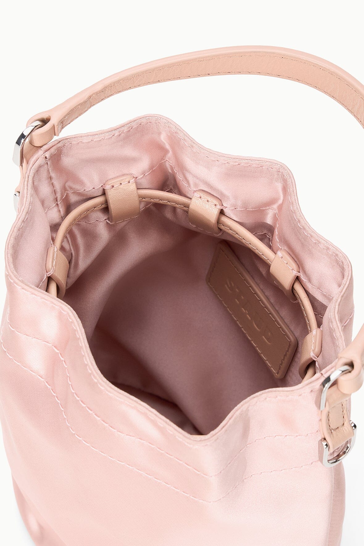 Blush mini bag interior with brown leather label and top zipper opening