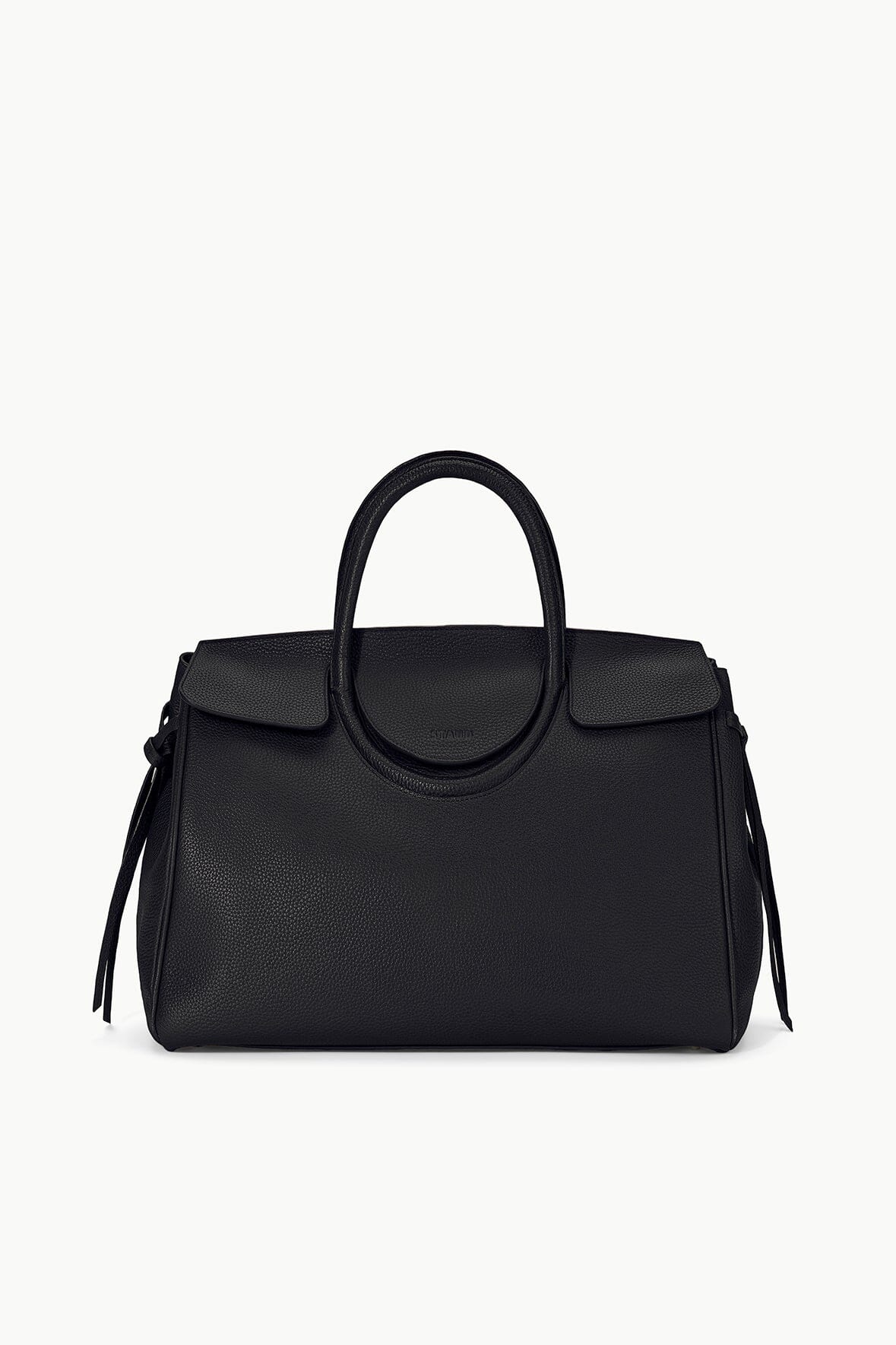 Maude carryall bag in black with curved top handle and side tassel accents.