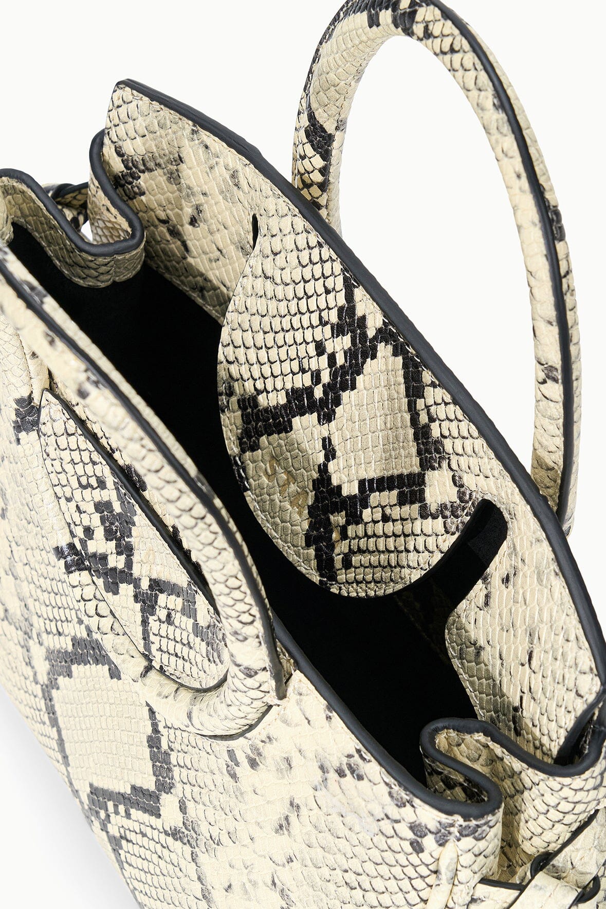 Maude mini carryall interior with white snake-print exterior and black-lined side pocket