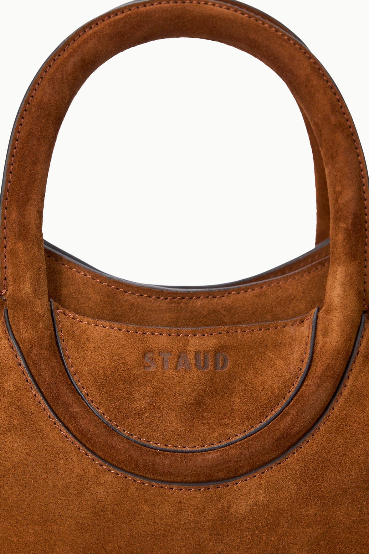 Tabac suede mini tote handle close-up with stitched trim and embossed logo