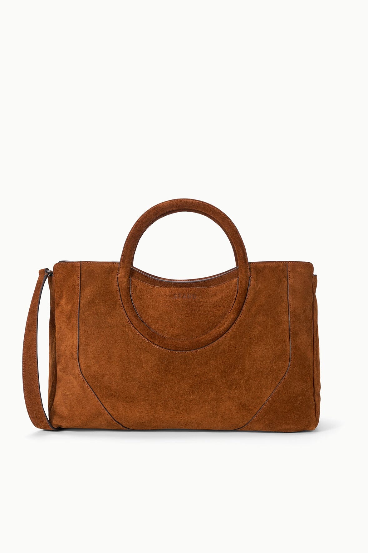 Brown suede satchel with crossbody strap, double handles, and curved front seam detail