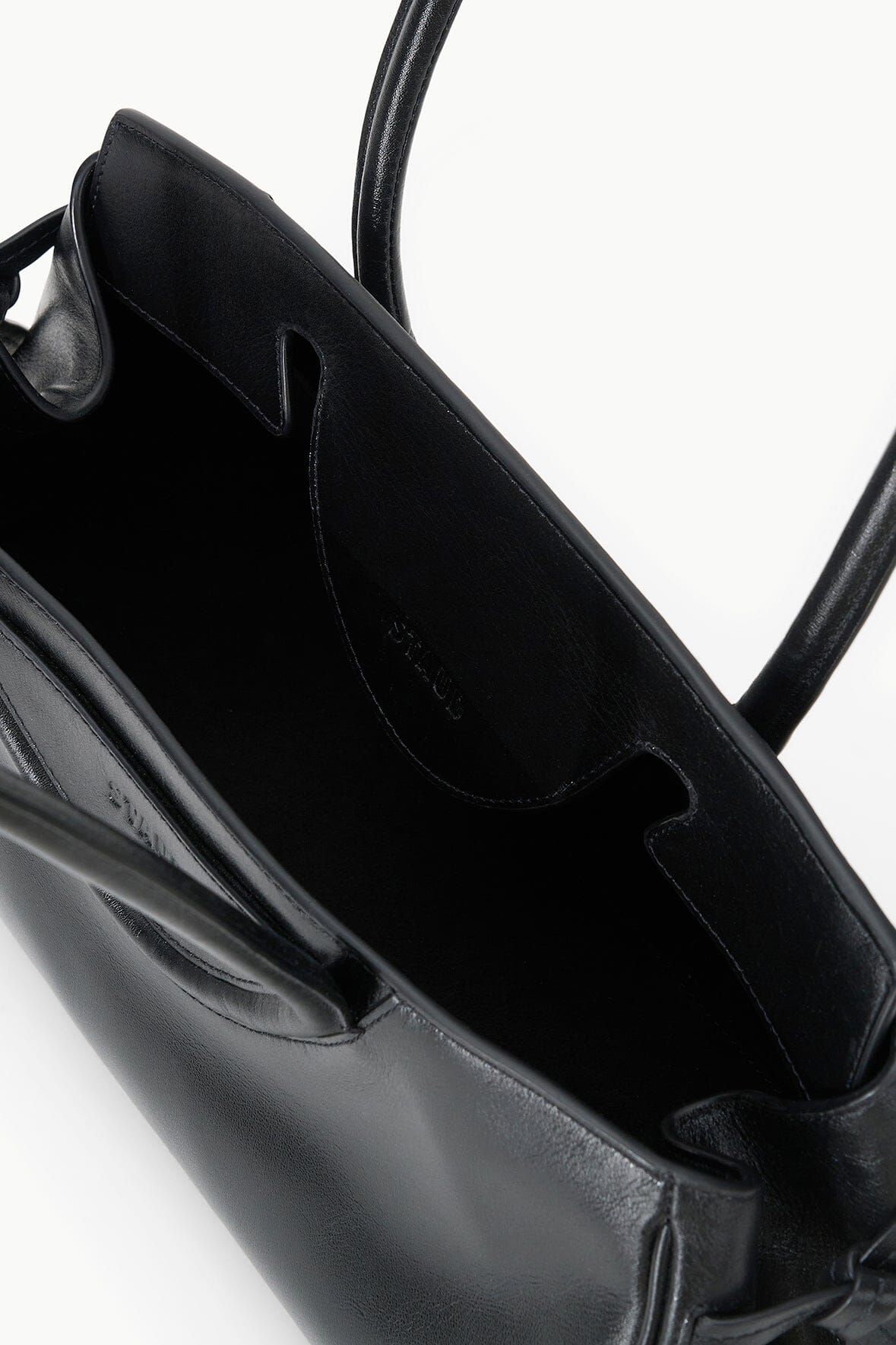 Black shoulder bag interior with stitched pocket and top handle