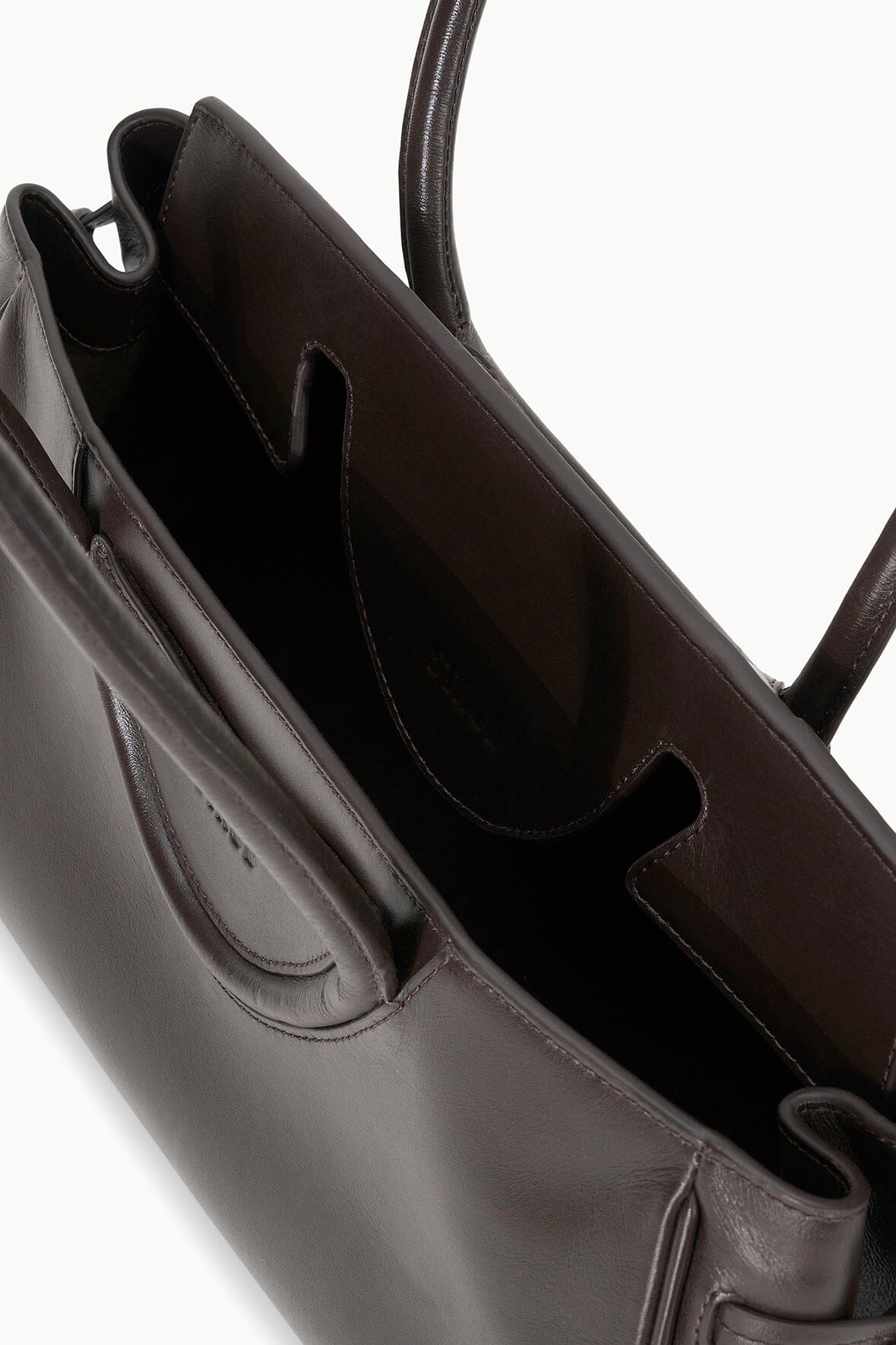 Espresso-brown leather shoulder bag interior with slip pockets and lined opening
