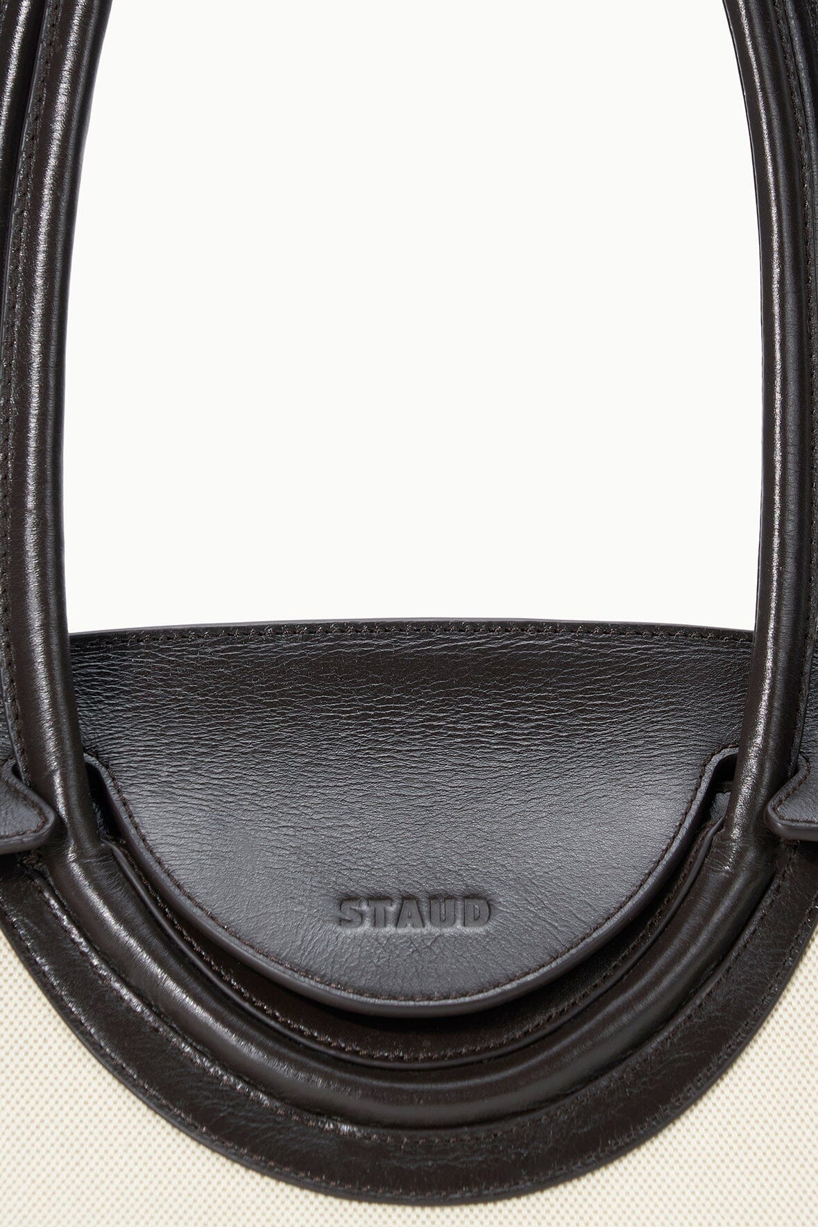 Maude shoulder bag close-up of espresso leather handle strap with embossed brand
