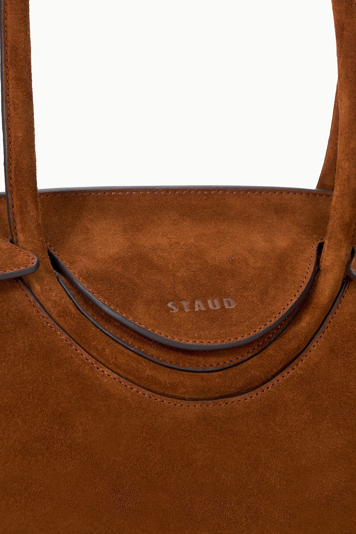Tabac suede shoulder bag inner pocket and brand stamp near curved edge