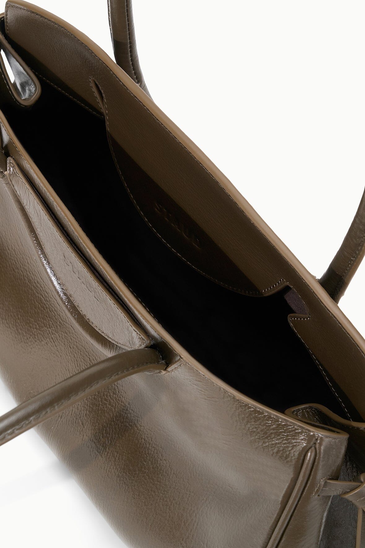 Brown leather shoulder bag interior view with top zipper opening and side pocket