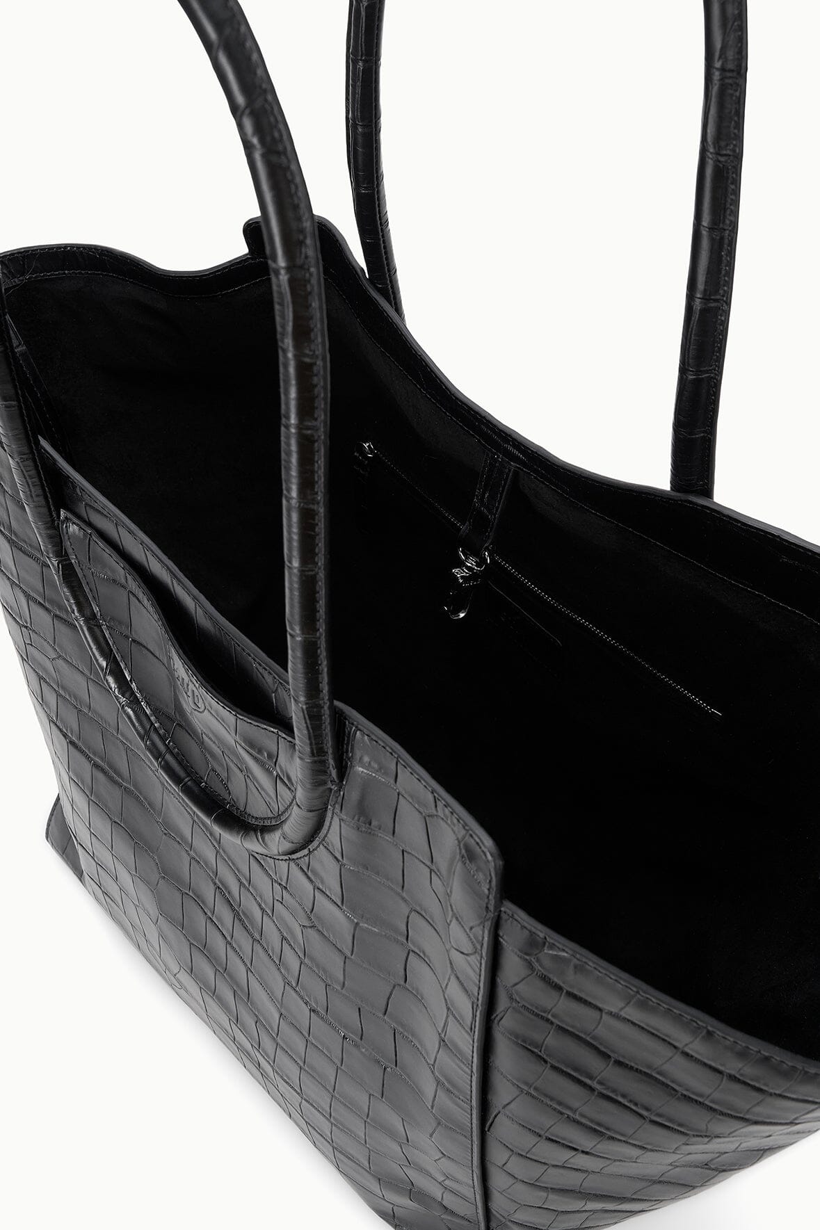 Black croc-effect tote bag side view with wide base and open top interior.