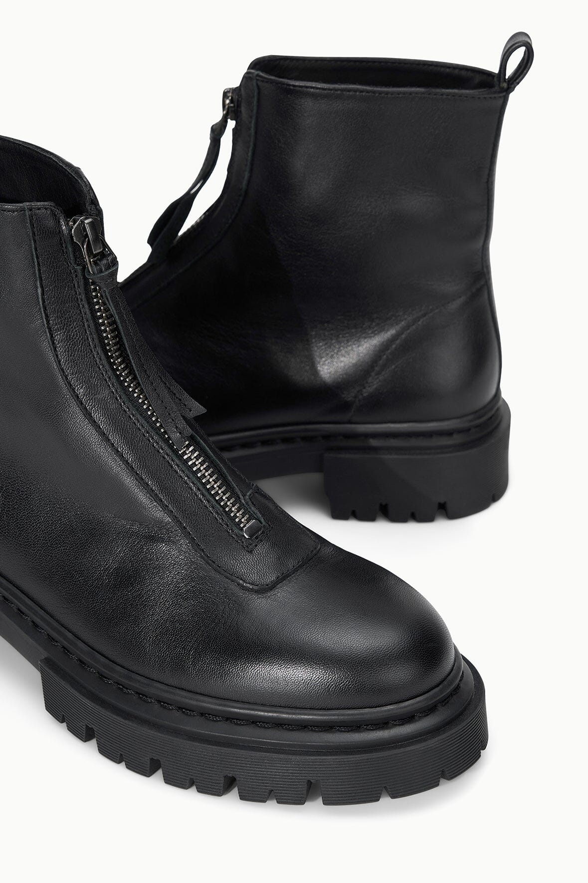 Black ankle boot with side-zip closure and chunky lug sole, front close-up.