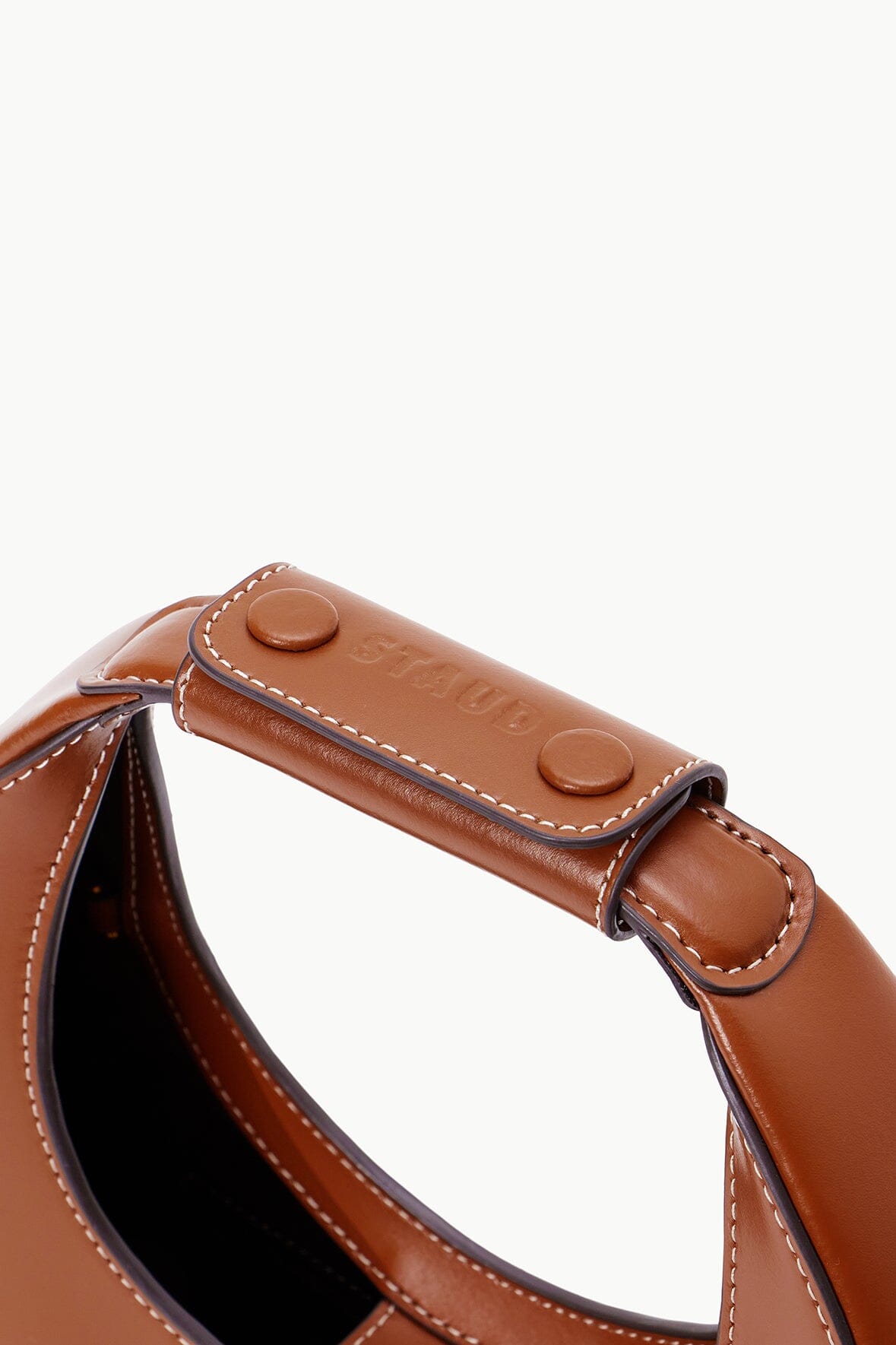 Mini moon bag tan leather handle with snap closure and stitched trim.