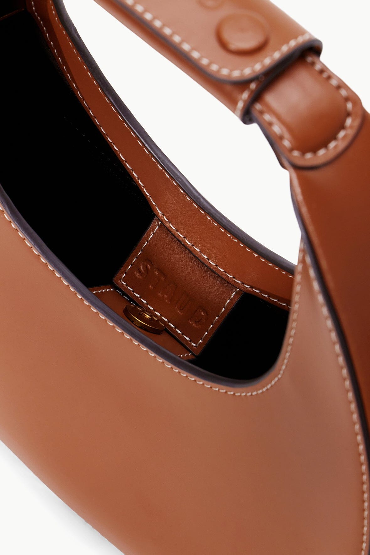 Mini moon bag tan leather with black-lined interior and contrast stitching detail.