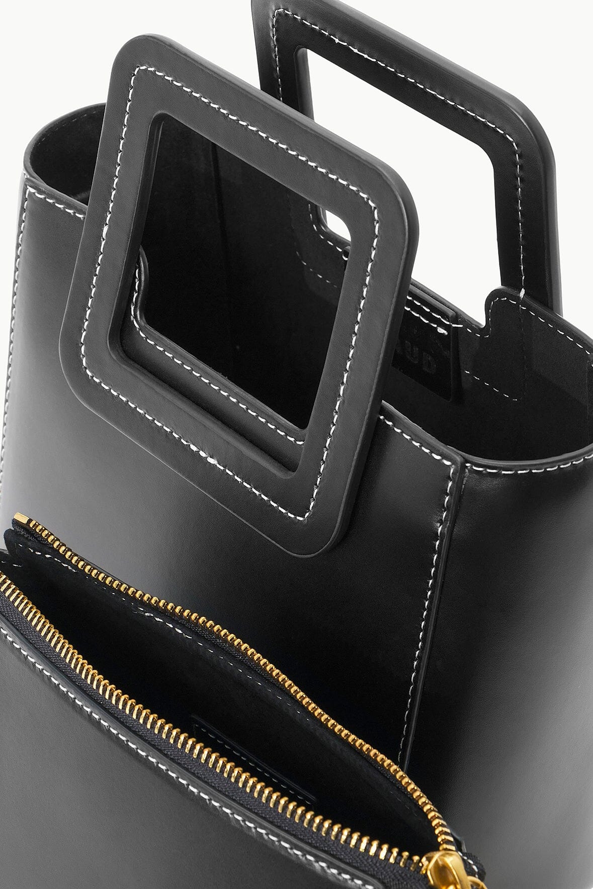 Black mini leather bag with gold zipper and contrast-stitched detailing
