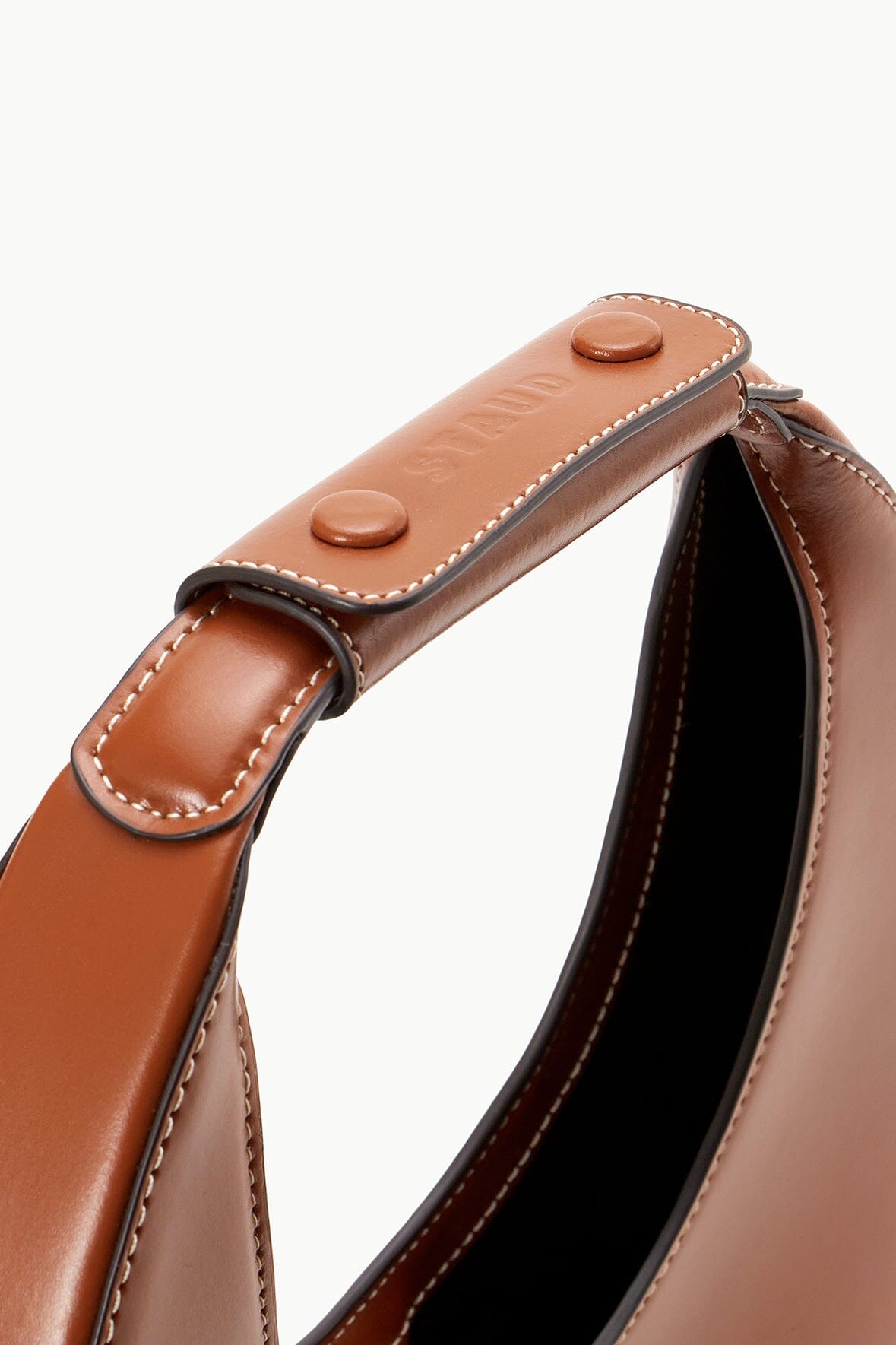 Tan moon bag close-up of top strap with snap buttons and contrast stitching