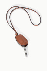 Tan-brown leather whistle pouch on cord with exposed metal whistle