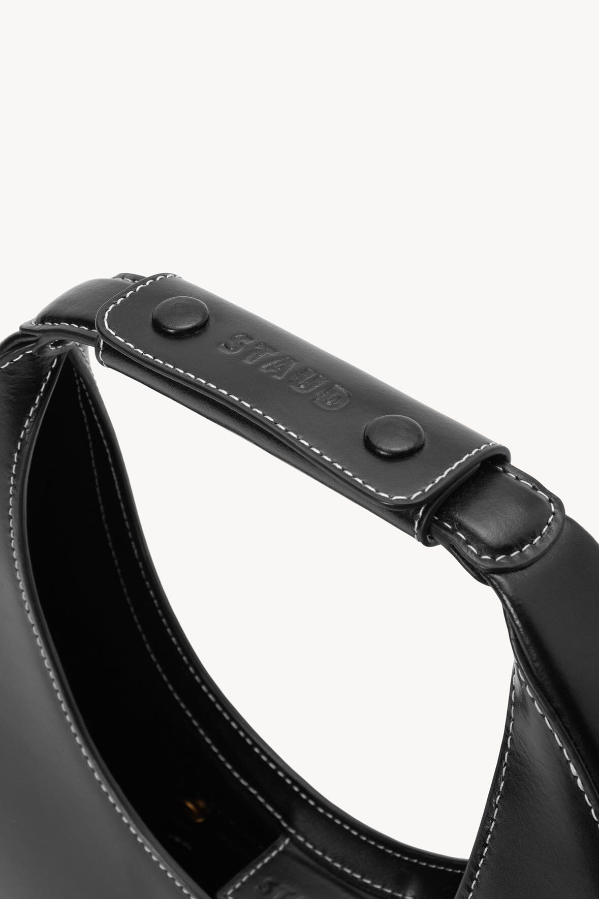 Black top handle with two snap buttons and stitched strap