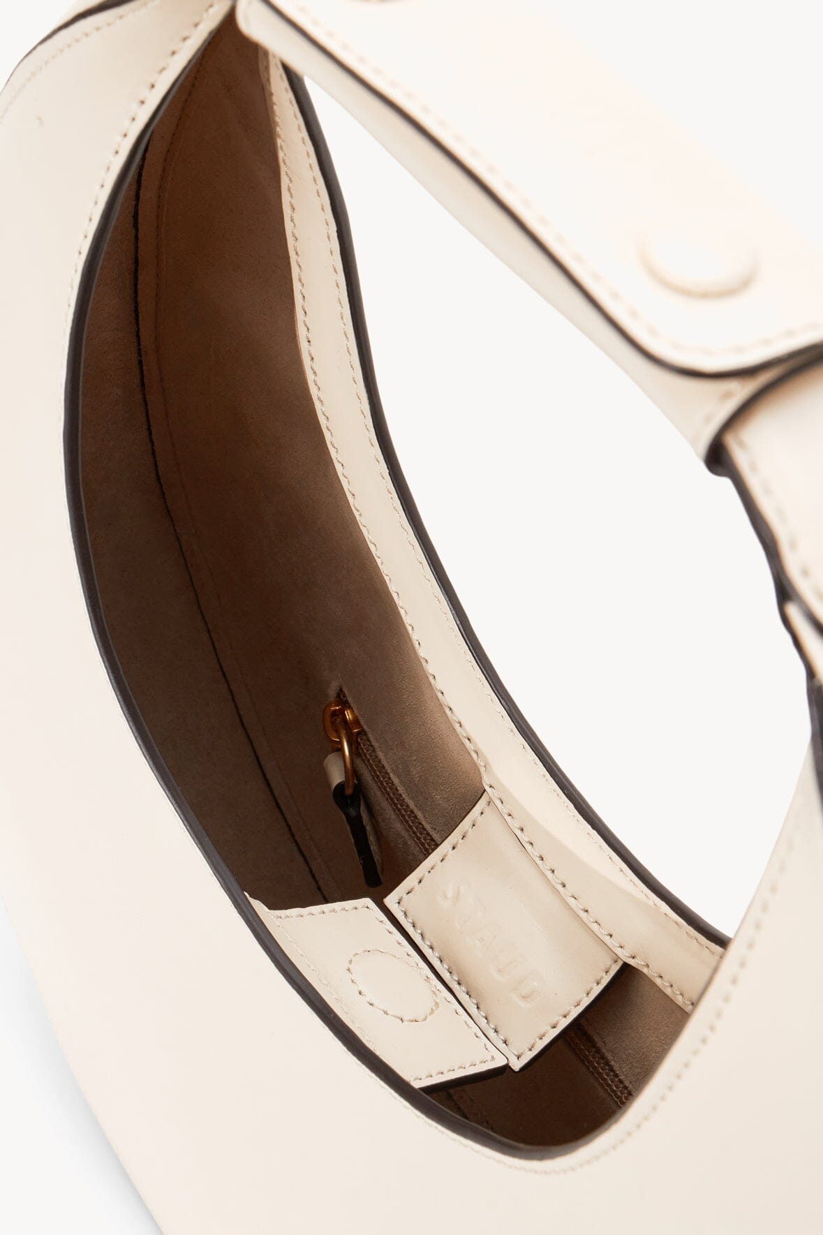 Cream crescent moon bag interior with brown lining and zip pocket