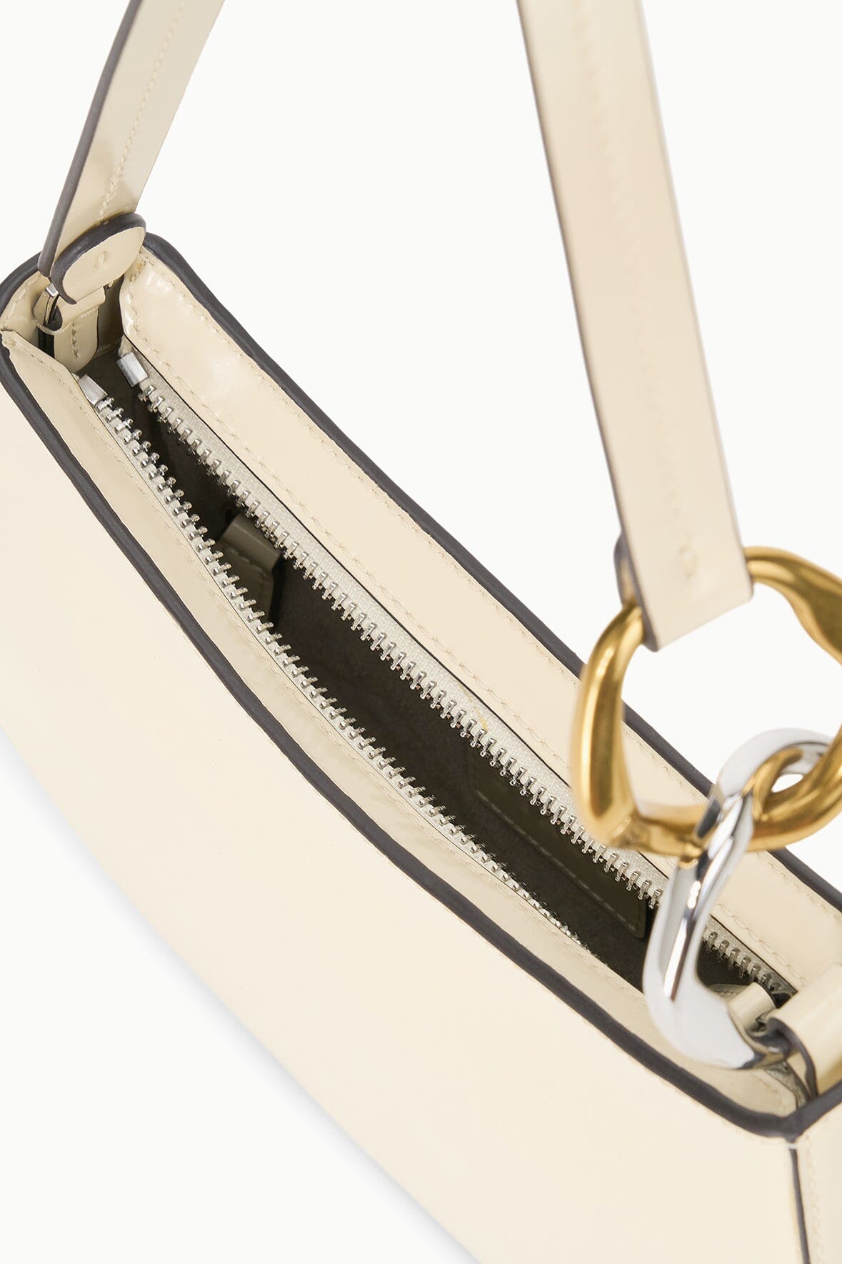 Close-up of cream hobo bag zipper opening with gold chain pull