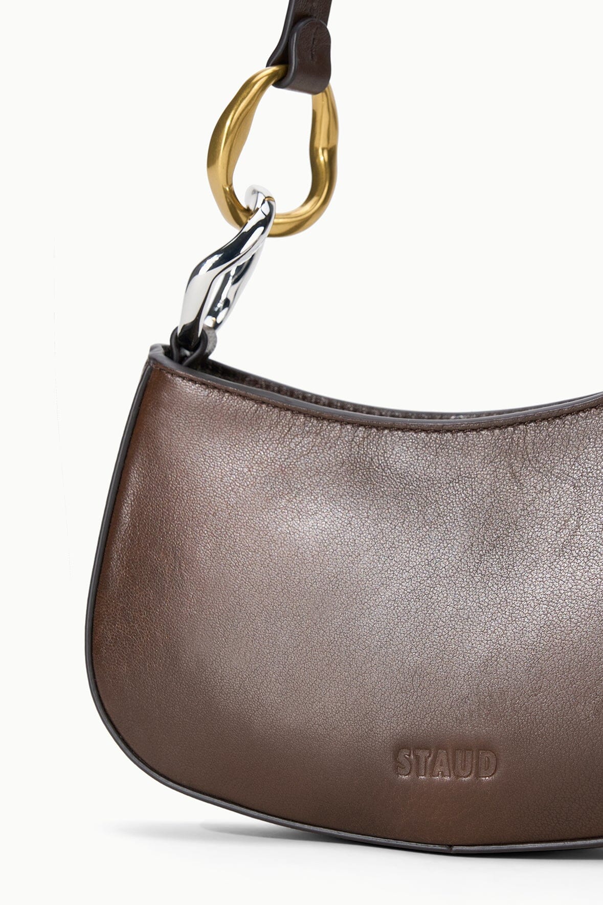 Ollie bag close-up: espresso-brown leather, gold chain ring detail, STAUD logo