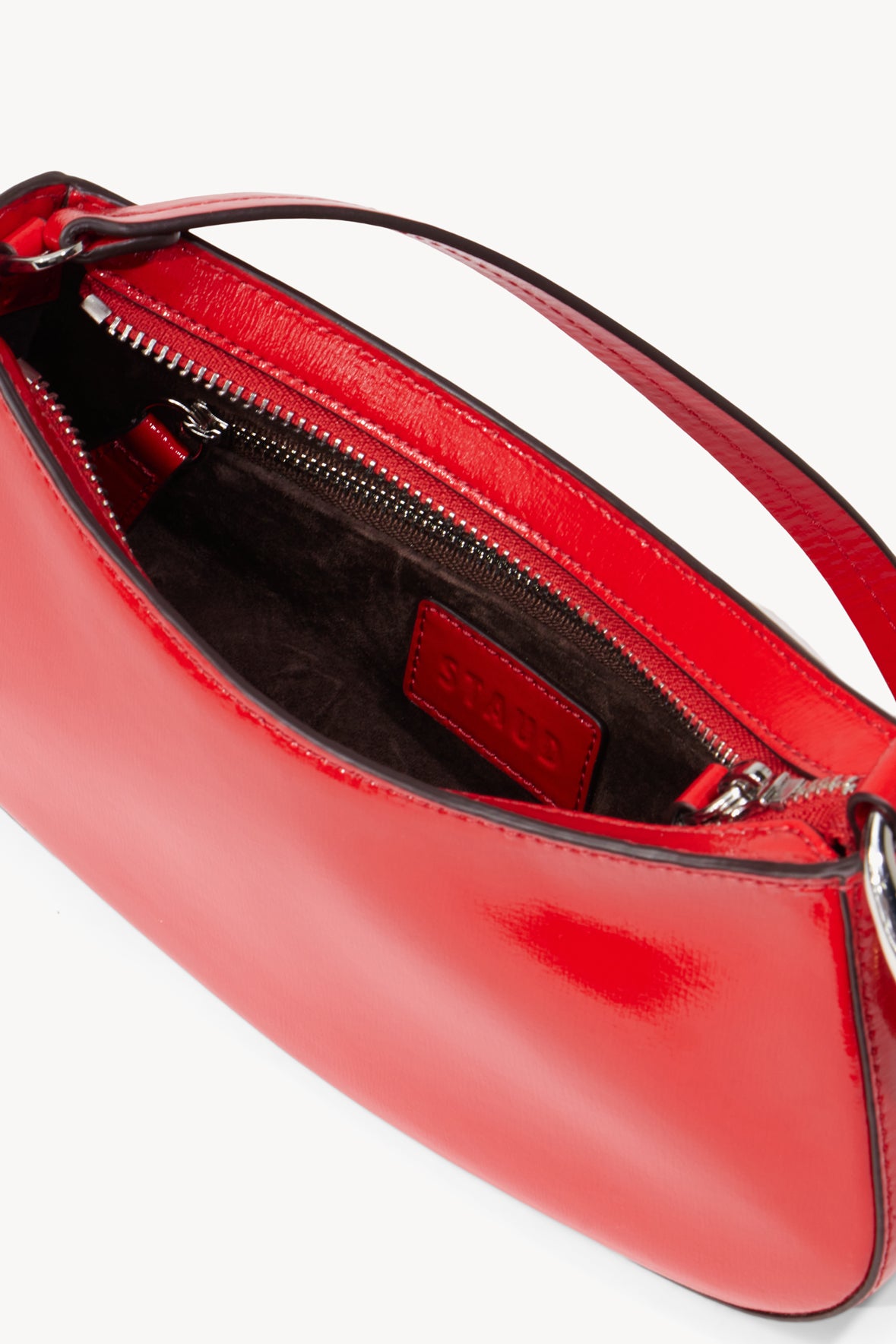 Red leather bag interior view with zipper and embossed logo patch