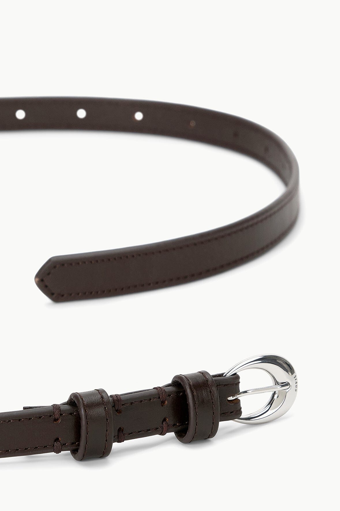 Slim brown leather belt with silver buckle, punched holes, and stitched edges
