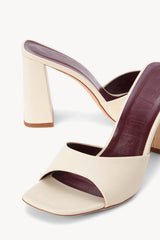 Cream heeled slide sandal with open toe and dark footbed