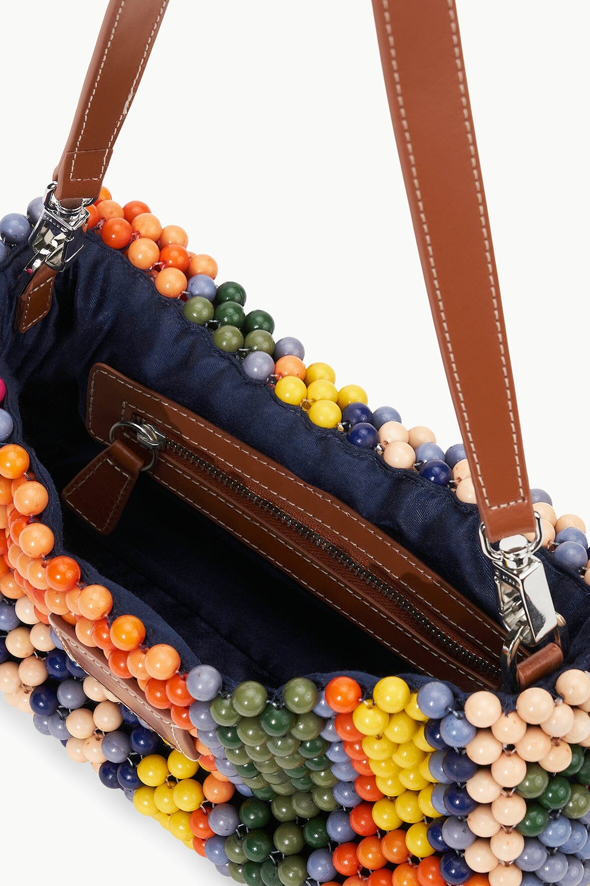 TIMMY shoulder bag detail with brown leather strap, dark fabric lining, and beaded trim.