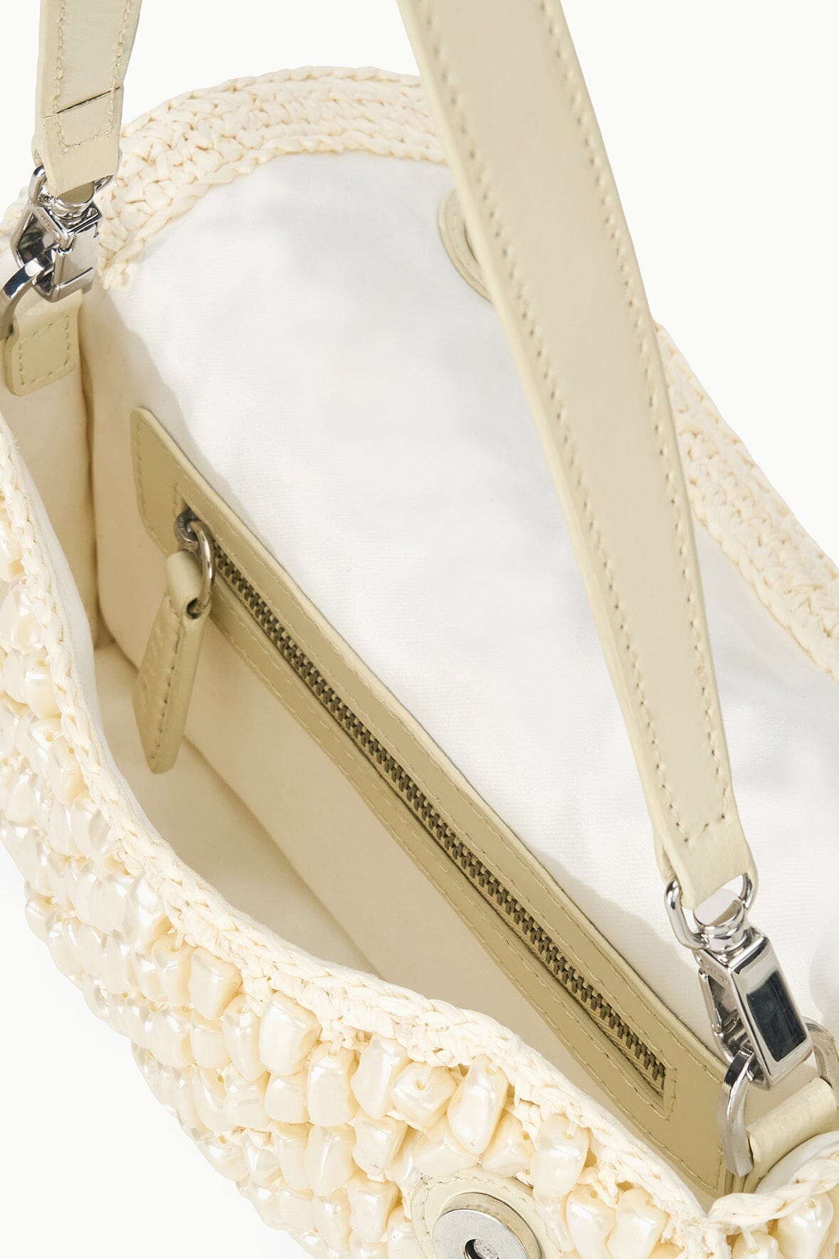 Cream woven shoulder bag interior view with zipper pocket and straps