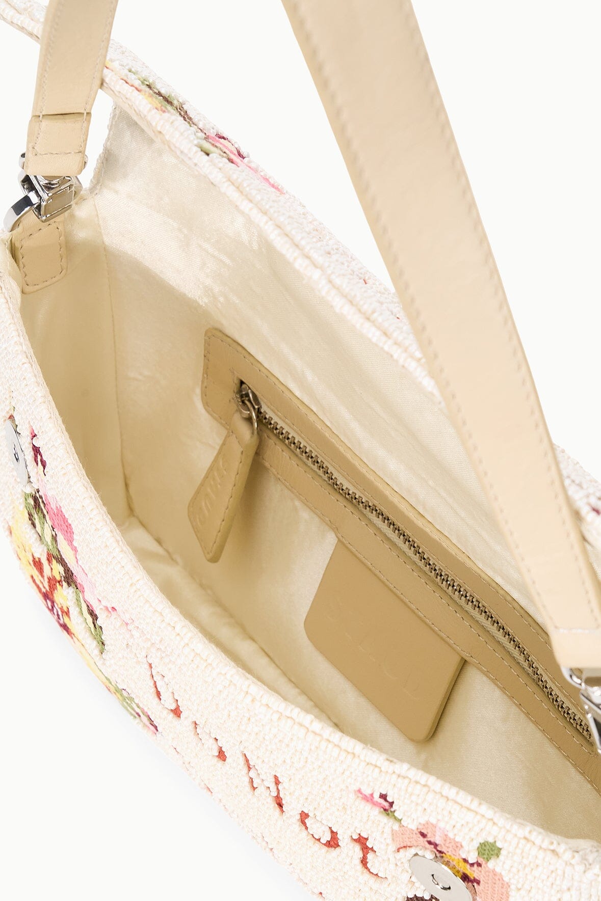Cream shoulder bag interior with beige lining and zip pocket, shown from an open top