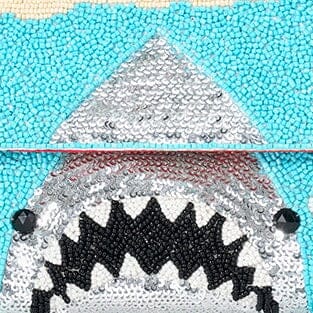 Close-up of turquoise sequin bag with silver shark triangle and black teeth.