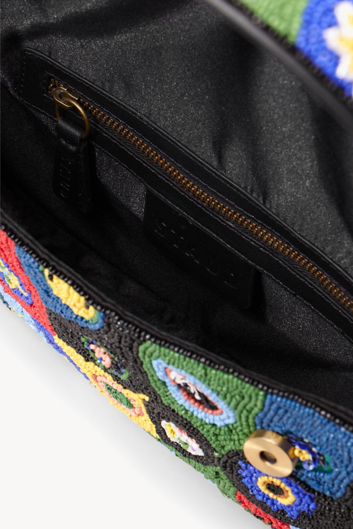 Beaded black flap bag with visible black lining and gold zipper.