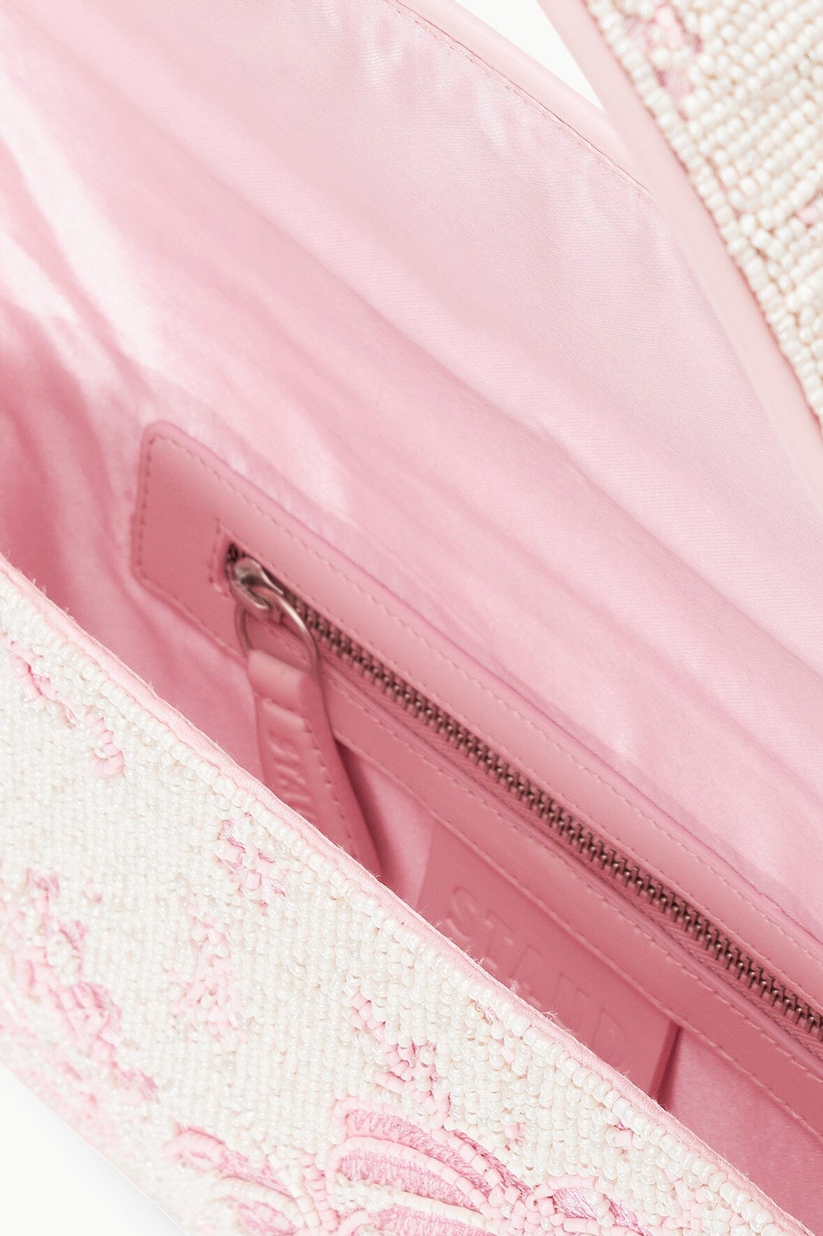 Beaded bag interior view with pink lining and zippered top closure