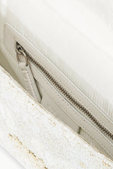 Beaded handbag interior view with zipper track and light lining.
