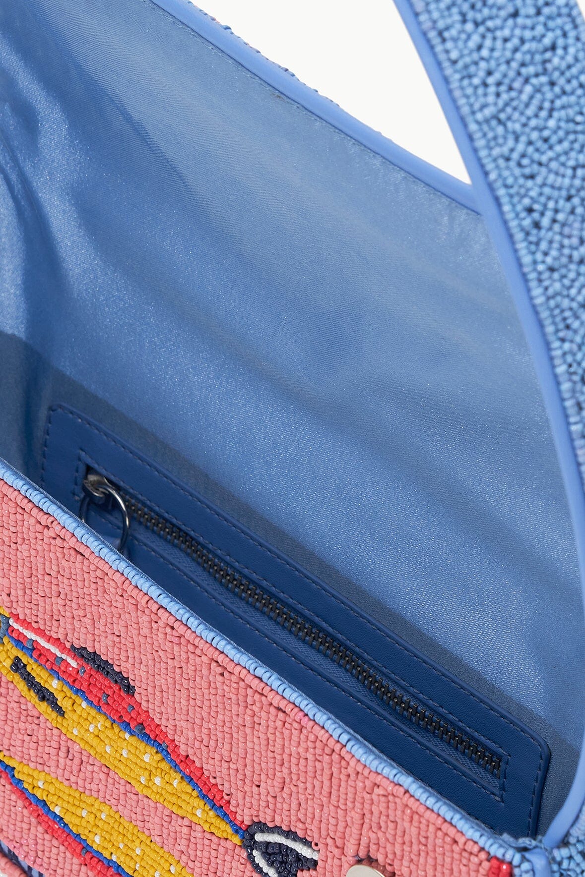 Open beaded bag interior with blue zipper and multicolor striped trim