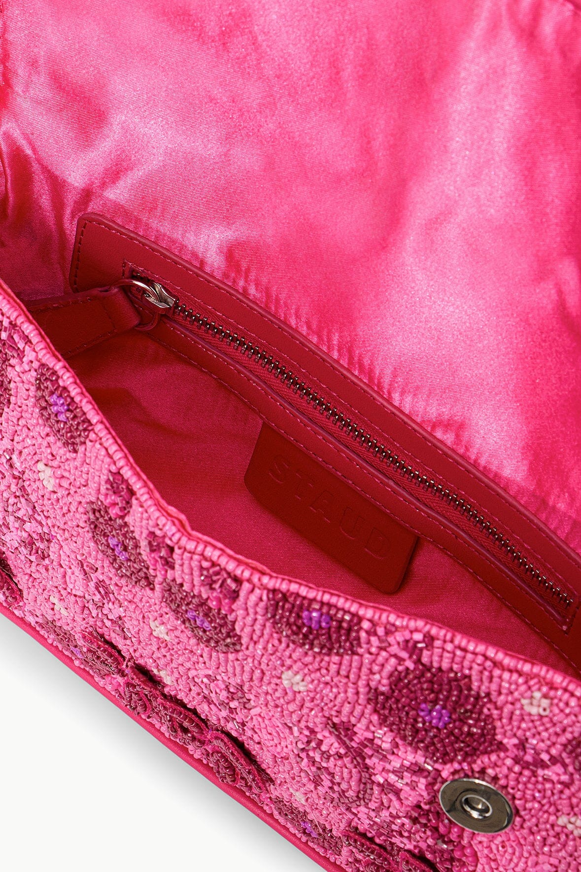 Pink beaded bag interior with fabric lining and zippered compartment.