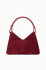 Burgundy suede shoulder bag with curved top handles and small logo patch