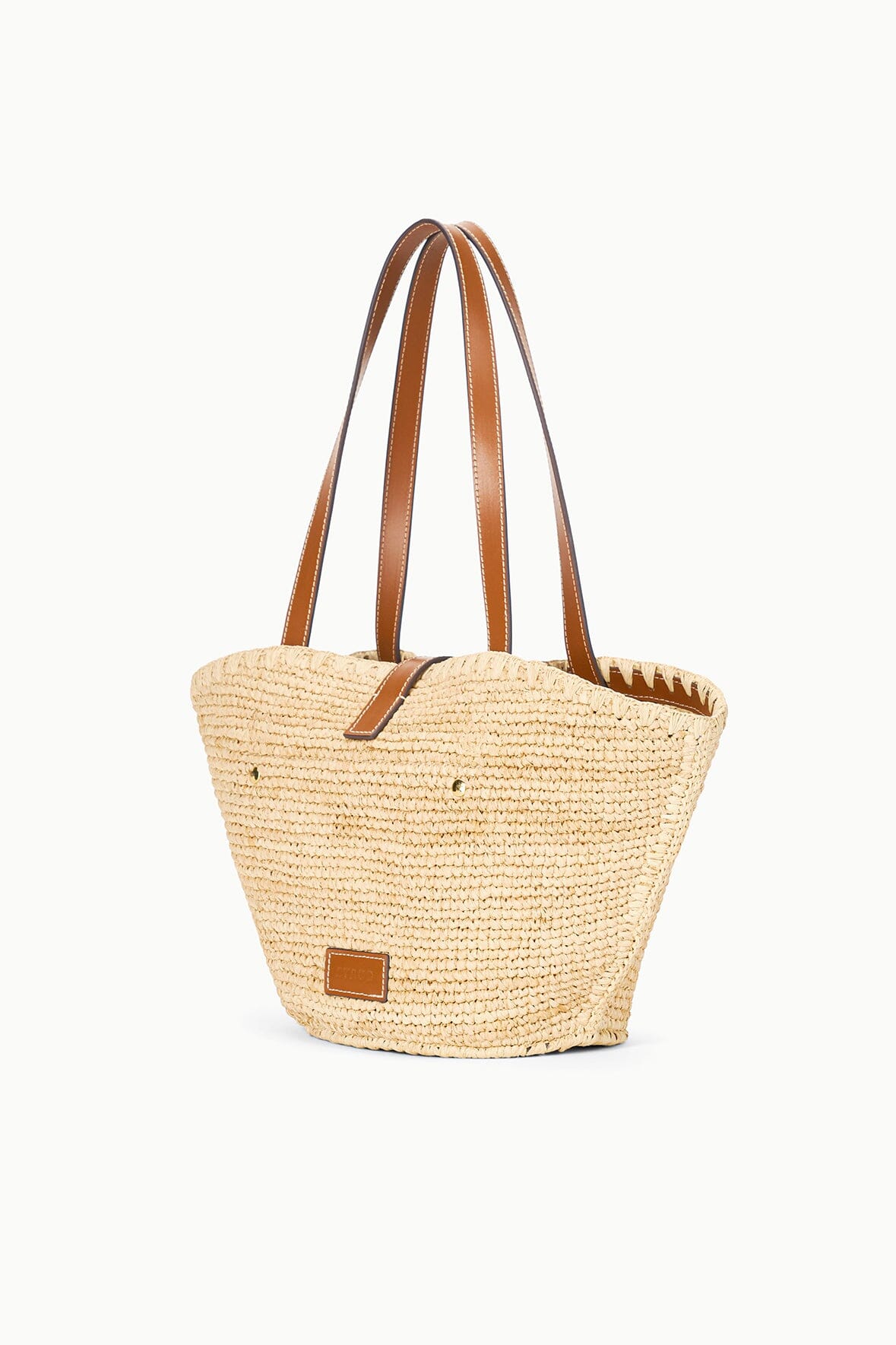 Natural tan woven tote bag with tan leather handles and small front patch