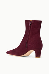 Suede ankle boot in syrah wine with side zipper and block heel.