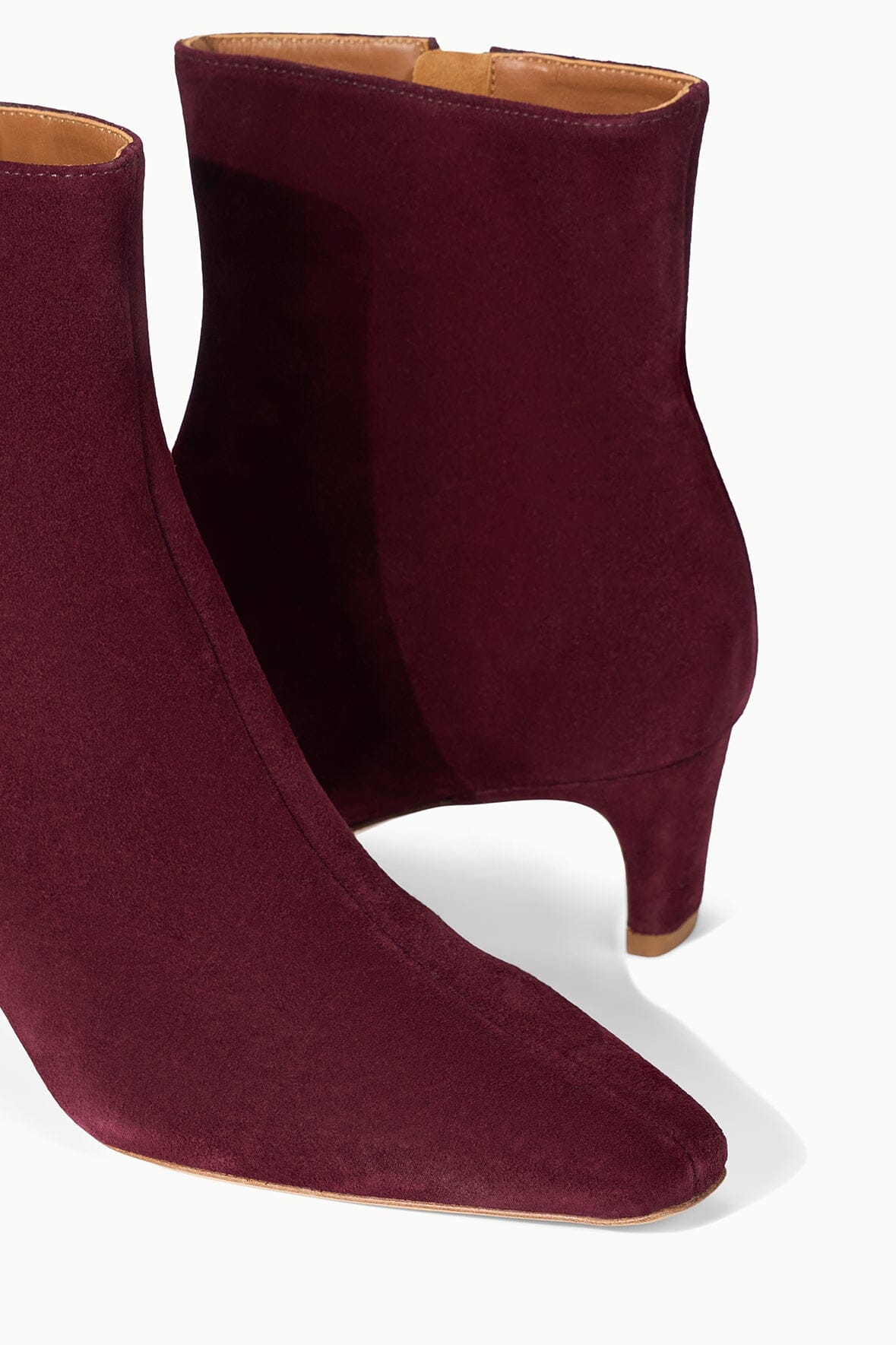 Suede ankle boot in syrah wine with open collar and stacked block heel.