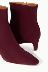 Suede ankle boot in syrah wine with open collar and stacked block heel.