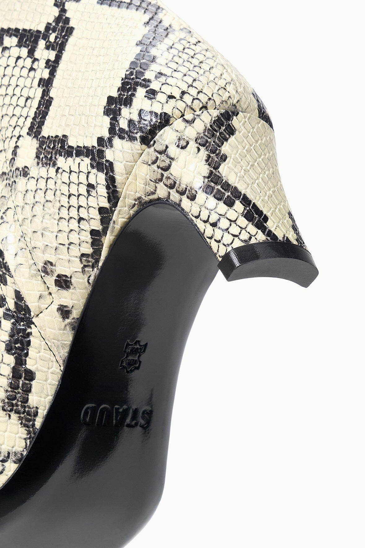 Close-up of white snake-print ankle boot with black heel detail