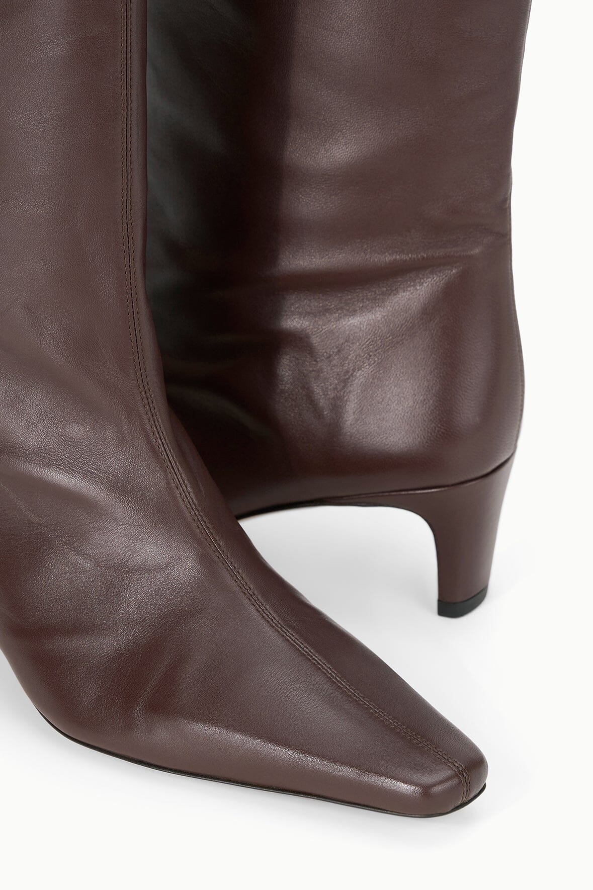 Espresso brown boot toe and heel close-up with curved sole edge