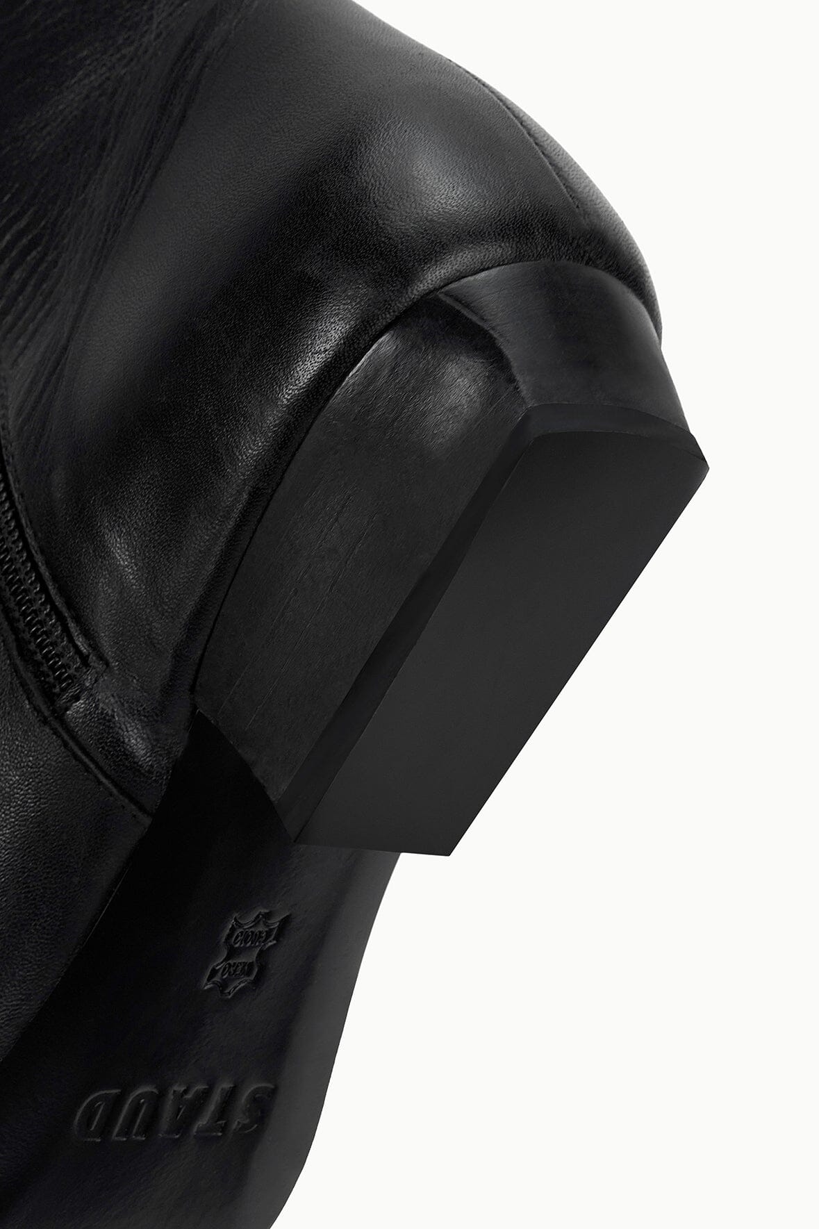 Black flat ankle boot heel-side close-up with embossed branding