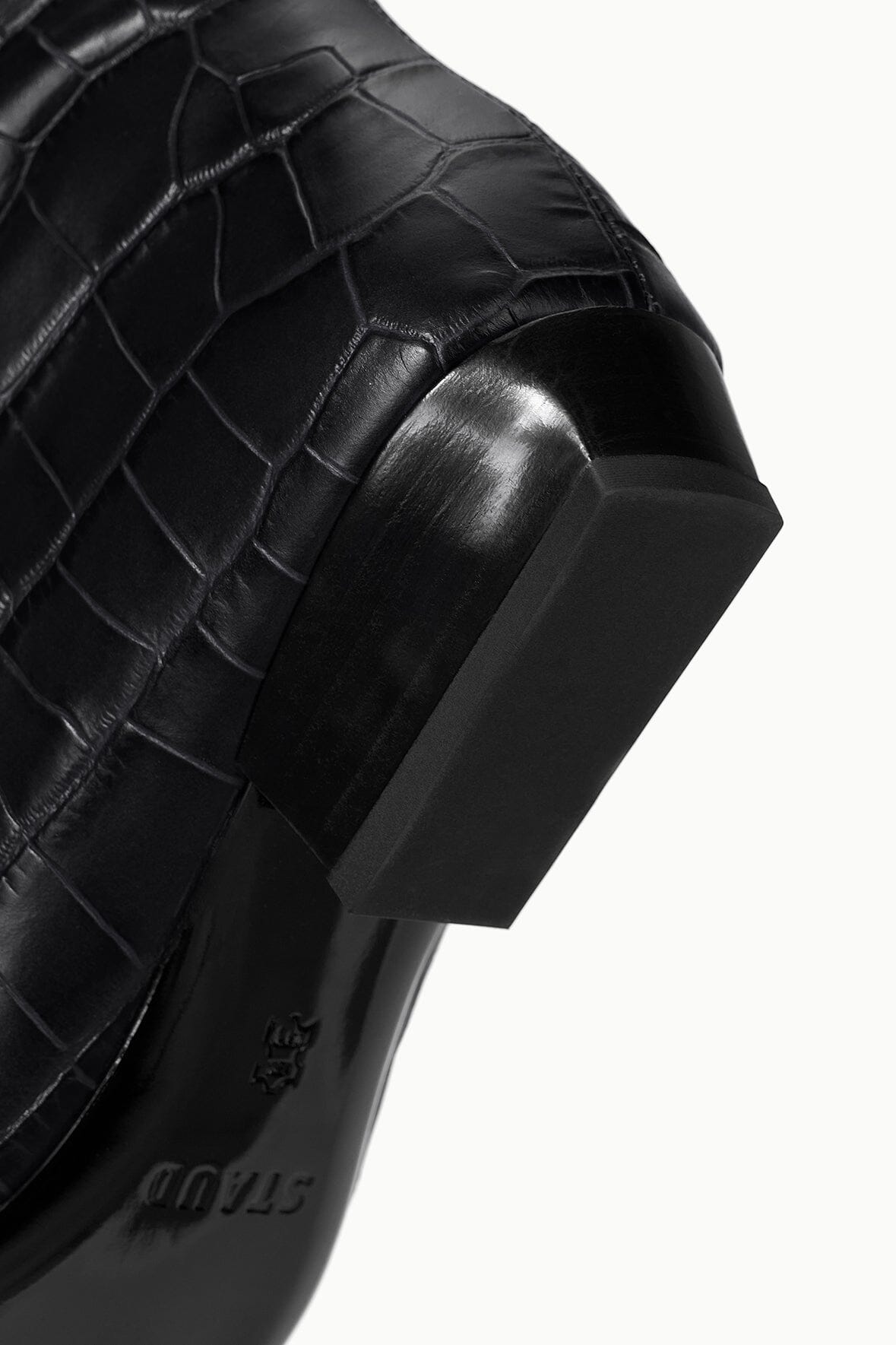 Black croc-embossed boot heel detail with stacked sole and textured finish