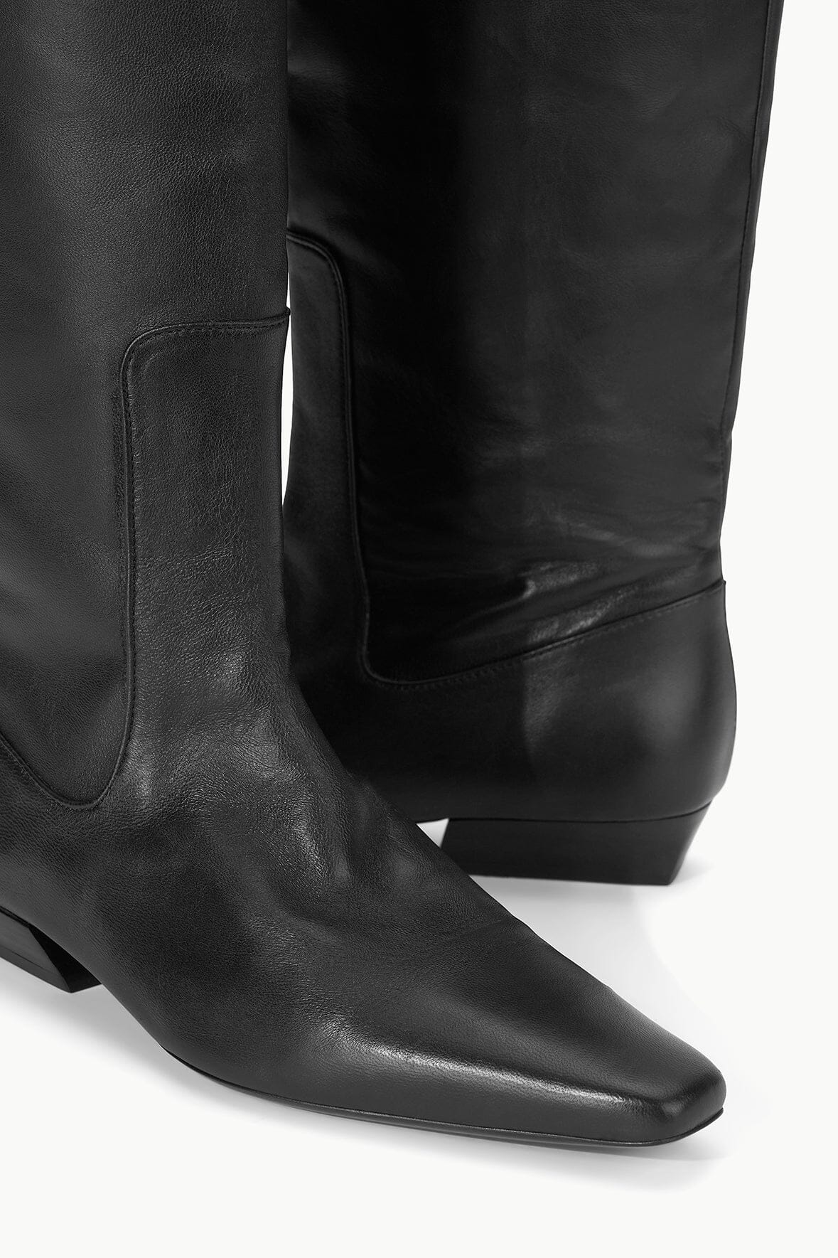 Black flat-heeled tall boot close-up of ankle seam and block heel