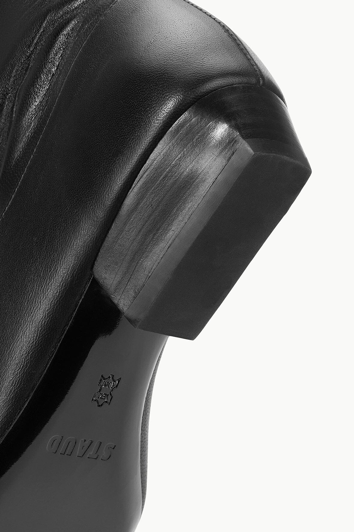 Black boot close-up of embossed heel logo and block heel