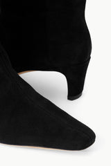 Black suede boot showing pointed toe and low stacked heel